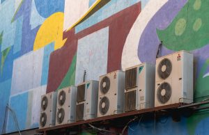 A few air conditioning units against a brightly colored wall